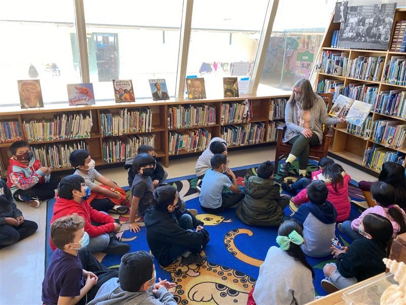 Photo of students listening to a read-aloud in the Dunbar Library